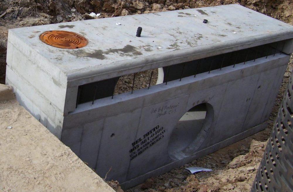 A photo of a standard concrete curb inlet that has been installed in an open excavation.