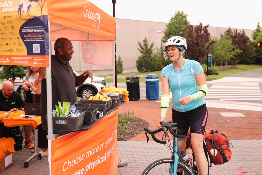Cyclists enjoys free snacks offered by volunteer at Bike to Work Day 2024.