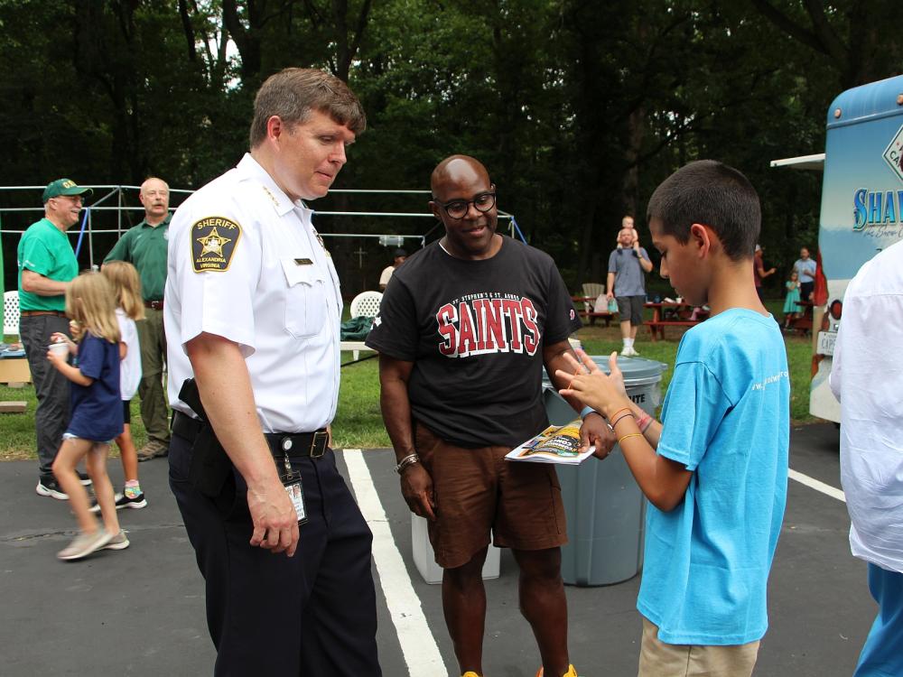 Sheriff and an adult neighbor watch a boy do a magic trick with string on his hands