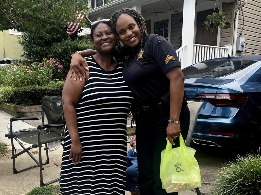 Resident and deputy sharing a hug at a National Night Out event