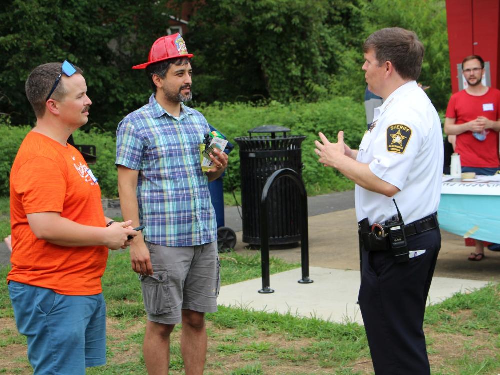 Two neighbors talking with Sheriff Casey at a National Night Out event for the Taylor Run Citizens' Association