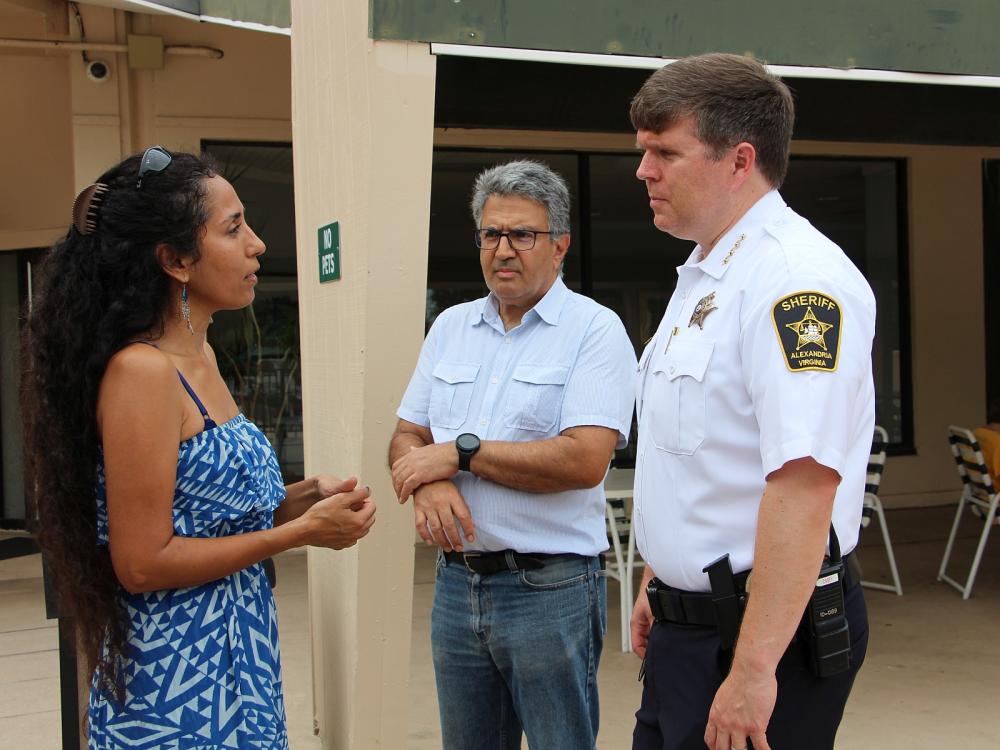 A resident speaking with the Sheriff while another neighbor looks on.