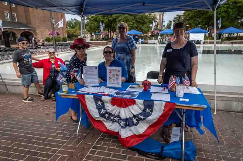 People at information table with flag bunting