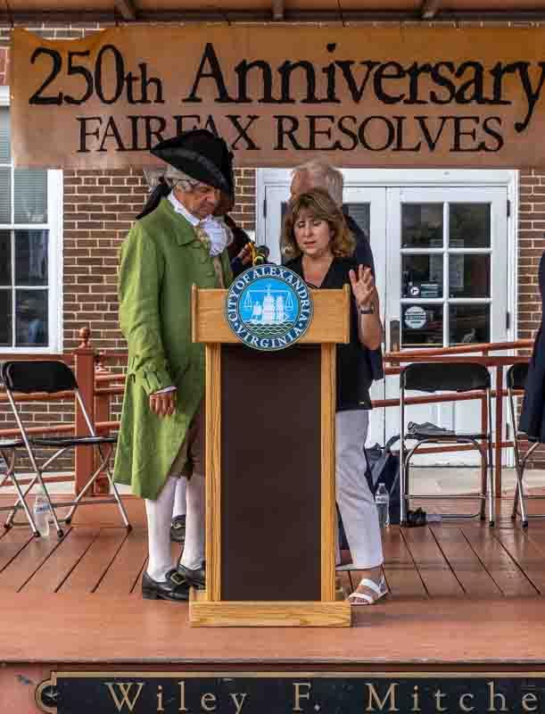 Gretchen Bulova at podium, with man in colonial attire