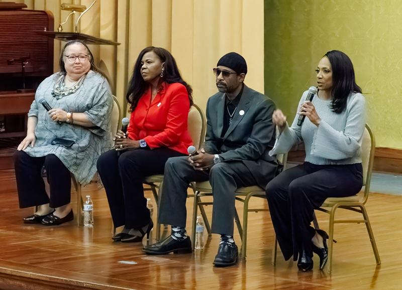 four-person panel on stage with microphones