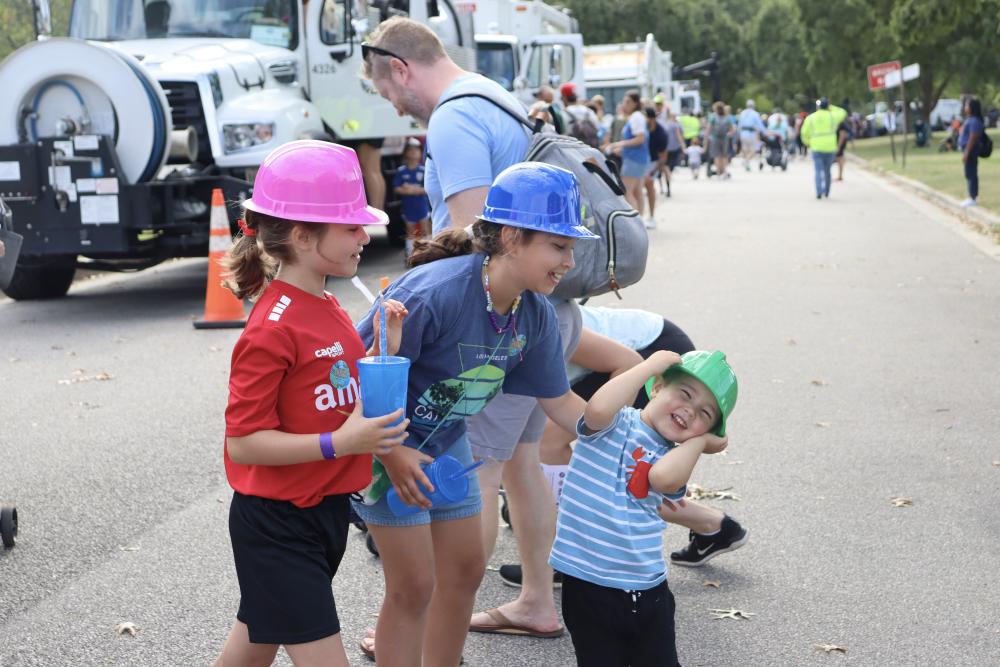 Parent and two kids wearing T&ES hard hats 2