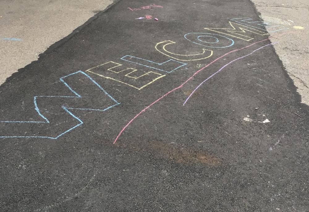 welcome written in chalk on a sidewalk in Alexandria