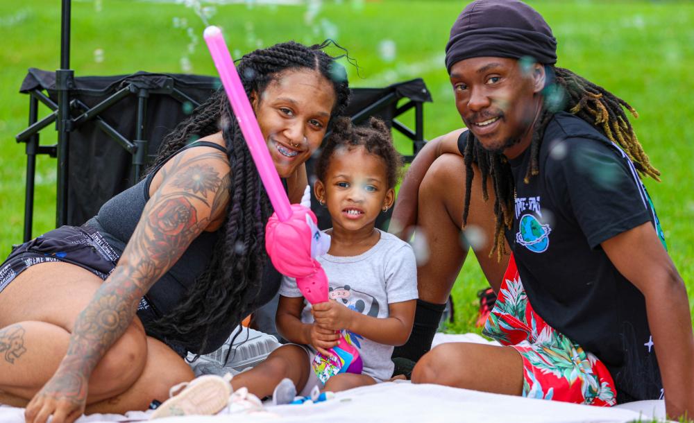 Family smiling, sitting on the lawn
