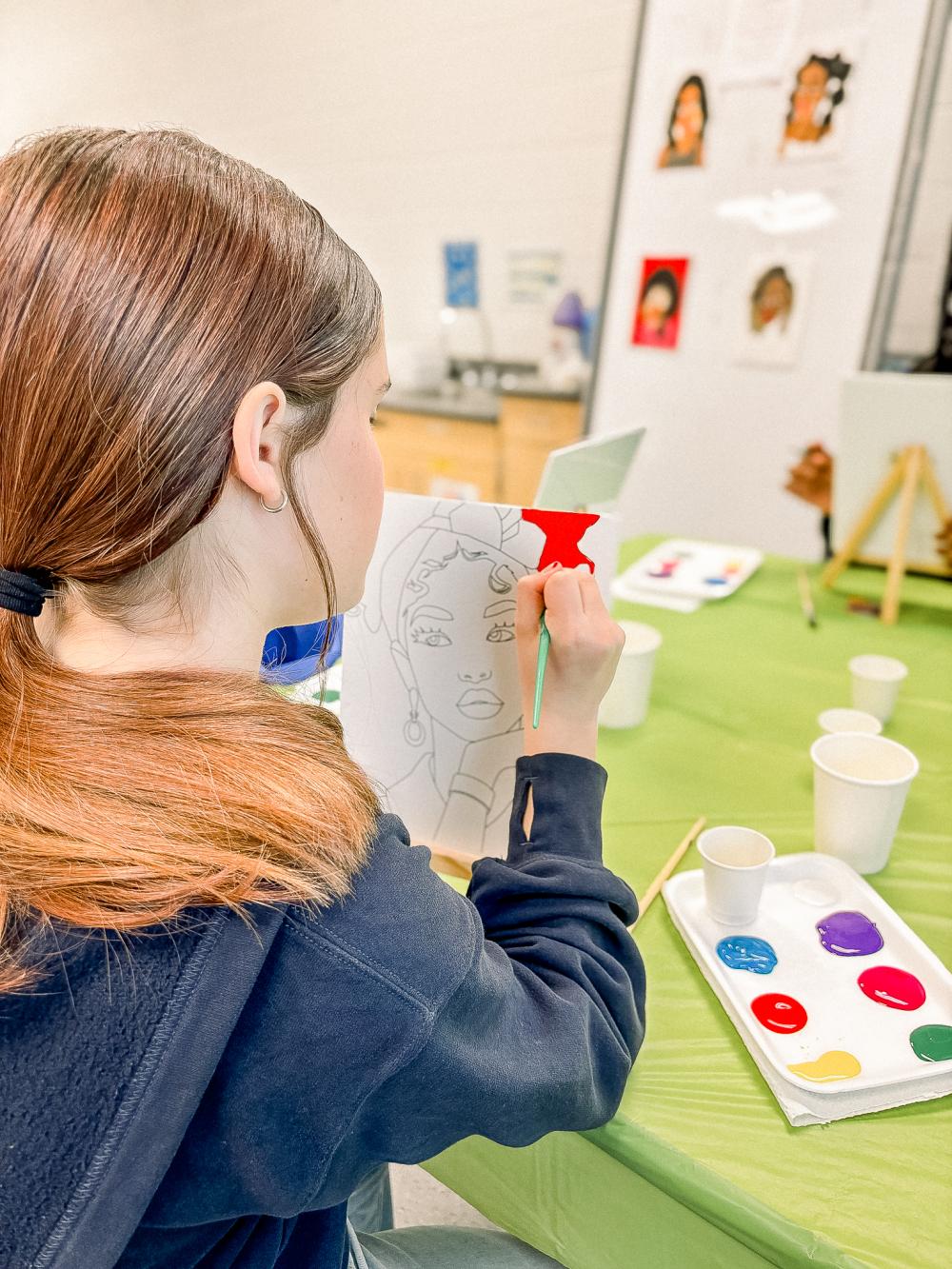 Teenage girl painting on a canvas