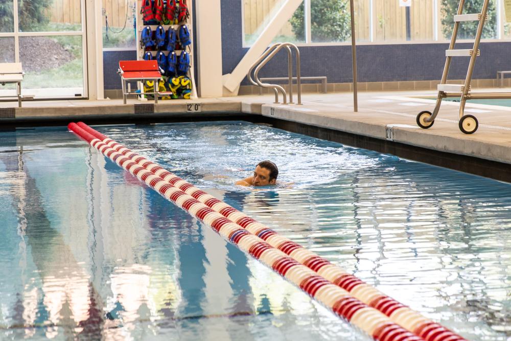 A man is lap swimming in the competition pool of Minnie Howard Aquatics Facility