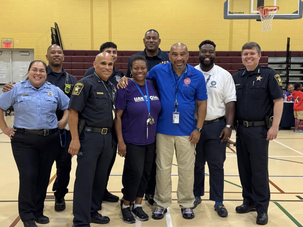 City staff posing and smiling inside the Charles Houston gym