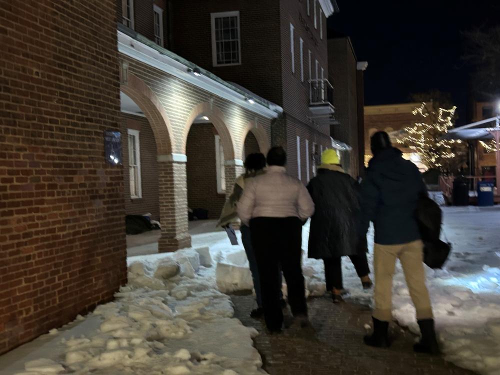 people walking up to City Hall in dark through snow