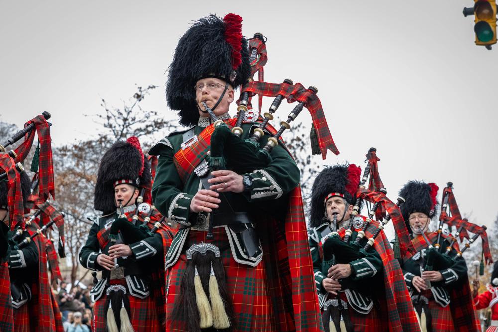 group in scottish garb playing bagpipes