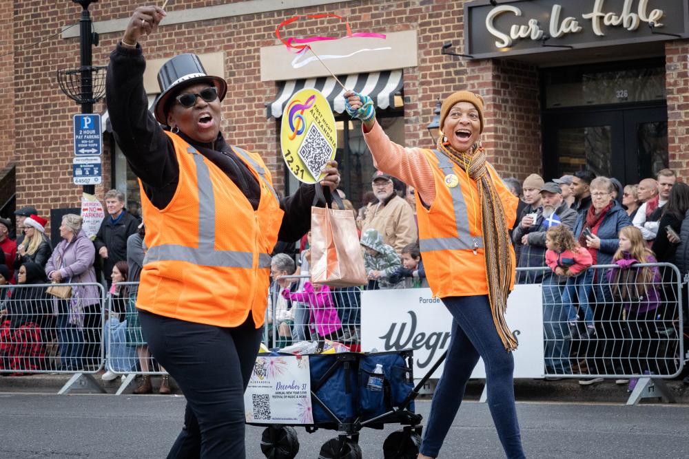 parade volunteers in high visibility vests handing out fans
