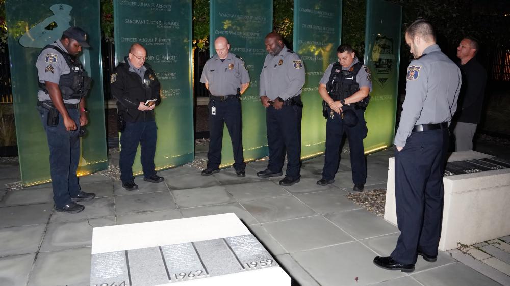 APD officers gather in prayer at the fallen officers memorial outside Police Headquarters, honoring those who gave their lives in service to Alexandria.