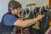 Conservator Josiah Wagner affixes the bell