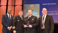 deputy receiving award with sheriff and two others standing with him