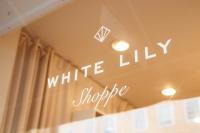 The glass storefront emblazoned with the store's logo "White Lily Shoppe"