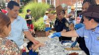 Community event with a family and public safety personnel sharing food wrapped in foil