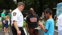 Sheriff and an adult neighbor watch a boy do a magic trick with string on his hands