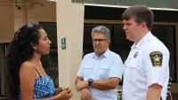 A resident speaking with the Sheriff while another neighbor looks on.