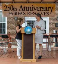 Podium and 25th Anniversary Fairfax Resolves banner, in front of City Hall