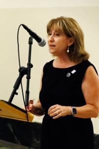 Gretchen Bulova at podium, speaking to audience