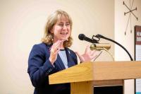 Gretchen Bulova at podium, speaking to audience