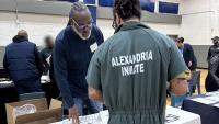 Inmate in a green jumpsuit speaking with an exhibitor who had brochures in front of him