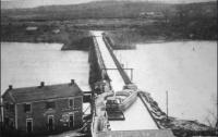 Photo showing a canal boat leaving the C&O Canal in Georgetown and entering the Alexandria Aqueduct to cross the Potomac River towards Alexandria. 