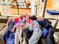 Group of teens huddled on the couch with lit up mics