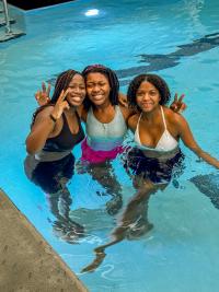 Teenage girls in the pool smiling at the camera