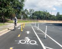 Person biking on Mill Road near Telegraph Road ramp at Pershing Avenue.