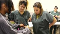 Instructor demonstrating braiding techinique to students who are inmates