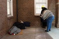 Photo of person who is homeless in sleeping bag outside