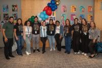 group of twelve standing next to each other smiling