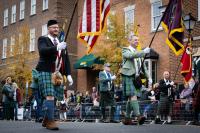 three men hold flags in front of them walking in parade
