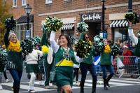 cheerleaders with pom poms waving to the crowd