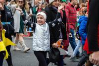 kid in silver vest and headband waving to the crowd