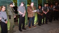 Officers bow their heads during a Faith & Blue remembrance gathering, sharing a moment of reflection before serving the community.
