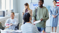 person taking ballot to vote