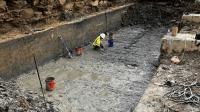 Archaeologist in canal lock, orange safety fencing