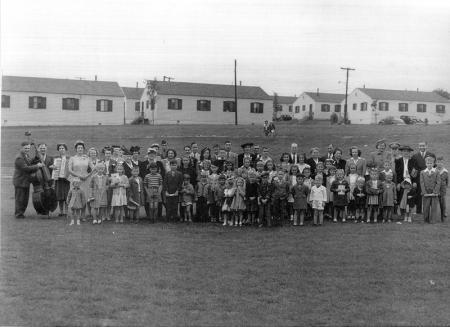 A group of people lined up for the photograph, in front of Chinquapin Village housing