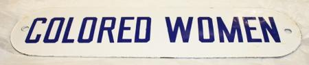 Colored women sign, with blue letters on white.