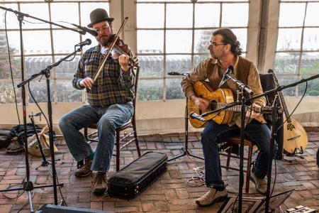 fiddle and guitar player in tent