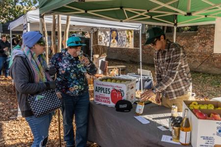 Two people at a cider tasting table