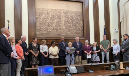 Members of the Alexandria Archaeological Commission present an annual award at the City Council meeting.