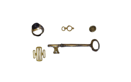 A small grouping of conserved metal objects that includes a ring and a key