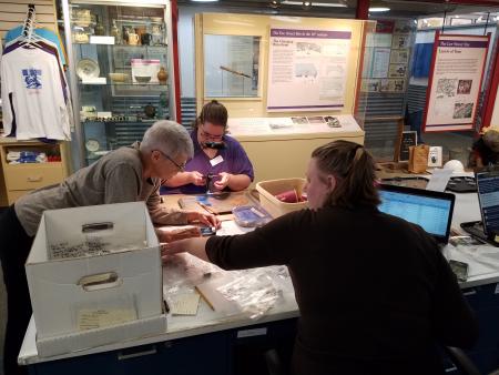 Archaeologists and volunteers work together to catalog cleaned and labeled artifacts