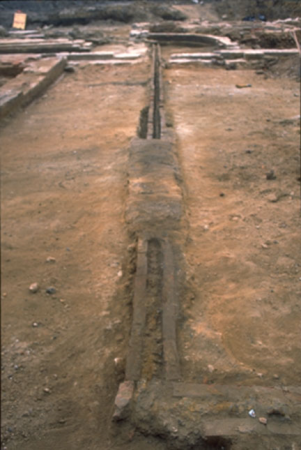 Excavations uncovered a straight, narrow brick channel encloses a long lead pipe.